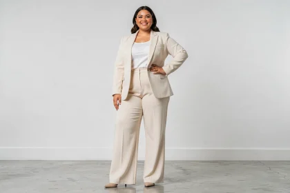 Femme mannequin grande taille en blazer crème posant avec confiance dans un studio photo minimaliste
